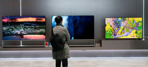 Man standing in front of three TVs