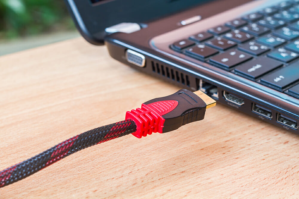 Red-black HDMI cable near a laptop