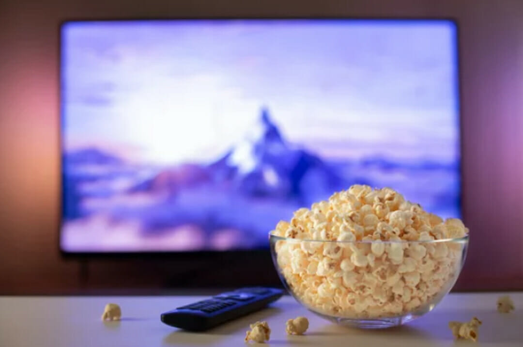 a monitor and a bowl with pop corn