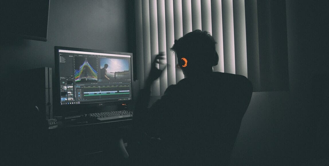 a person with headphones sitting in front of the monitor