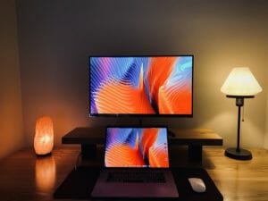 laptop and monitor between two lamps
