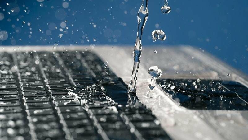 water spilling on a laptop