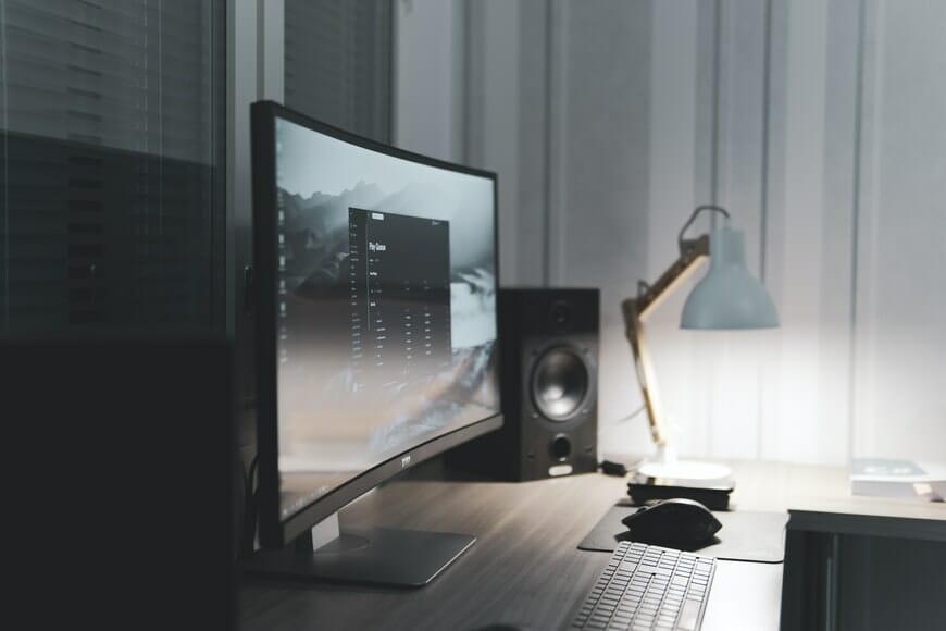 workspace with monitor, keyboard and lamp