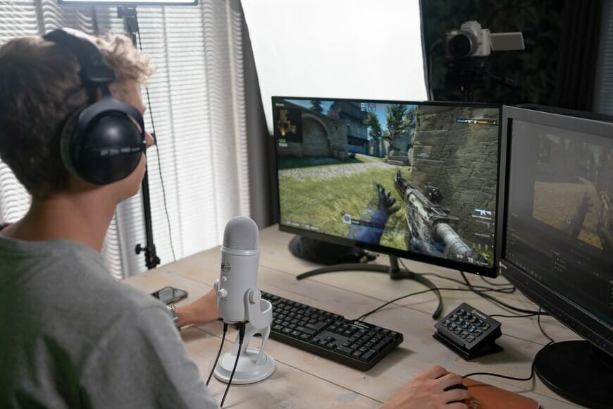 a gamer playing on two monitors