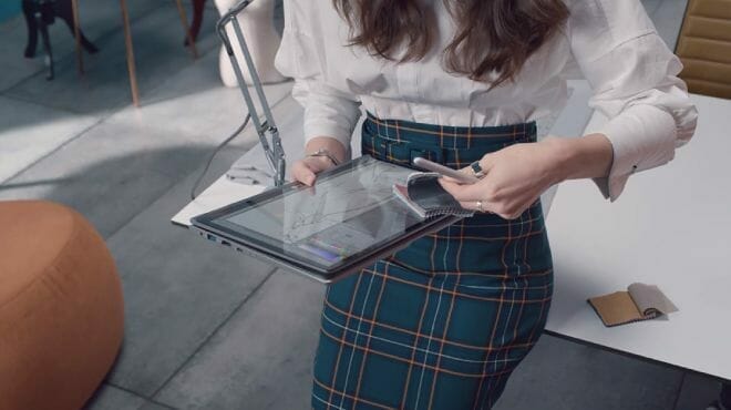 Woman in a skirt holding a foldable laptop
