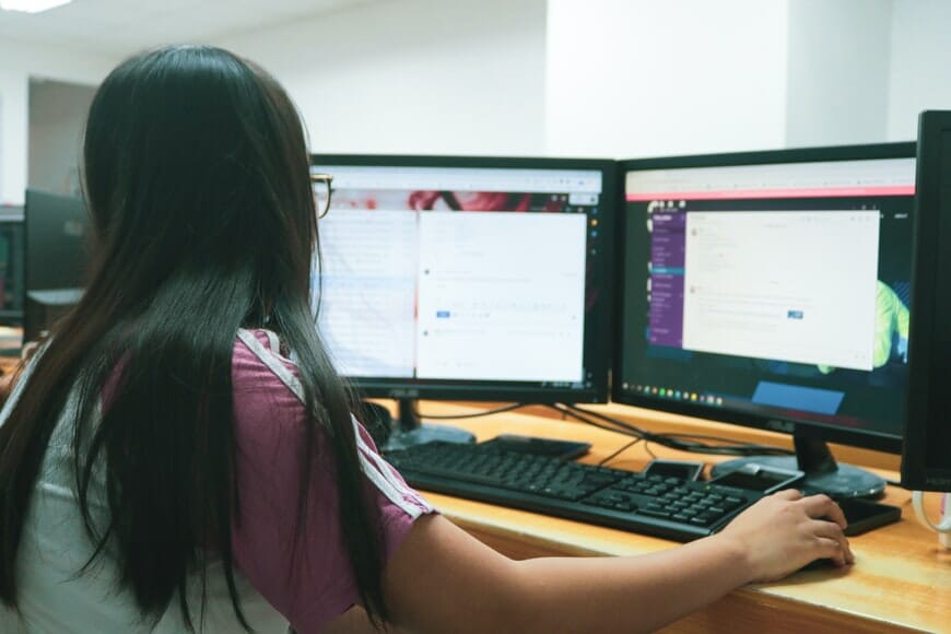 a person working in front of two monitors