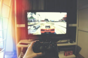 a person holding a gaming controller in front of the monitor