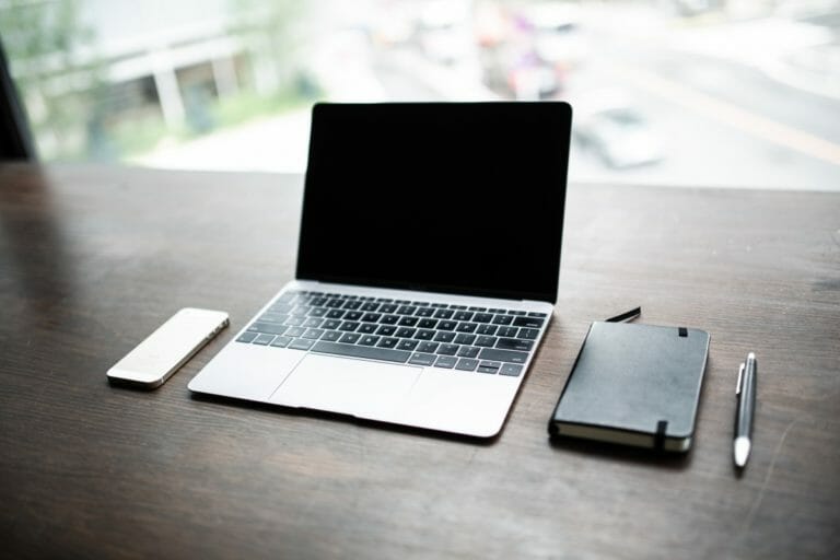 laptop, cellphone and notebook on the desk