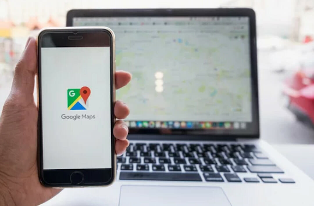 a person holding a phone with Google Maps icon on the screen