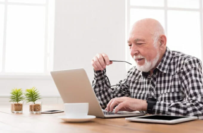 an elderly man using a laptop