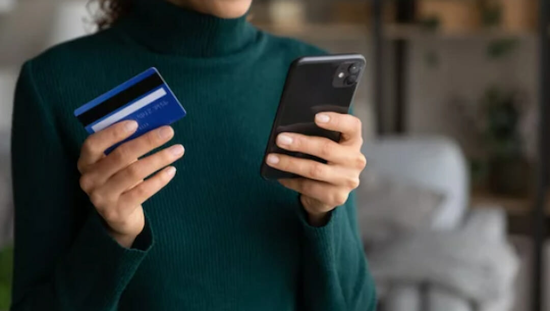 a woman holding credit card and mobile phone in her hands