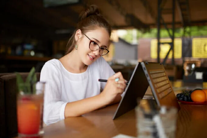 a young woman drawing on laptop screen