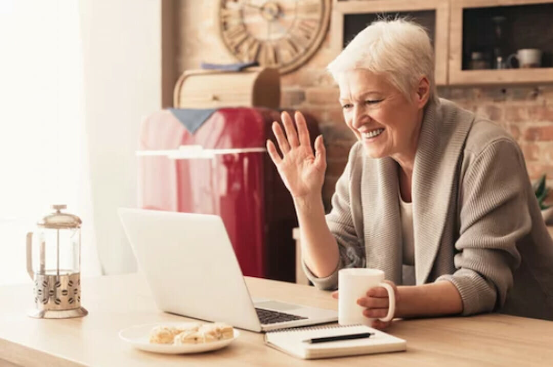 a smiling senior lady having an online chat