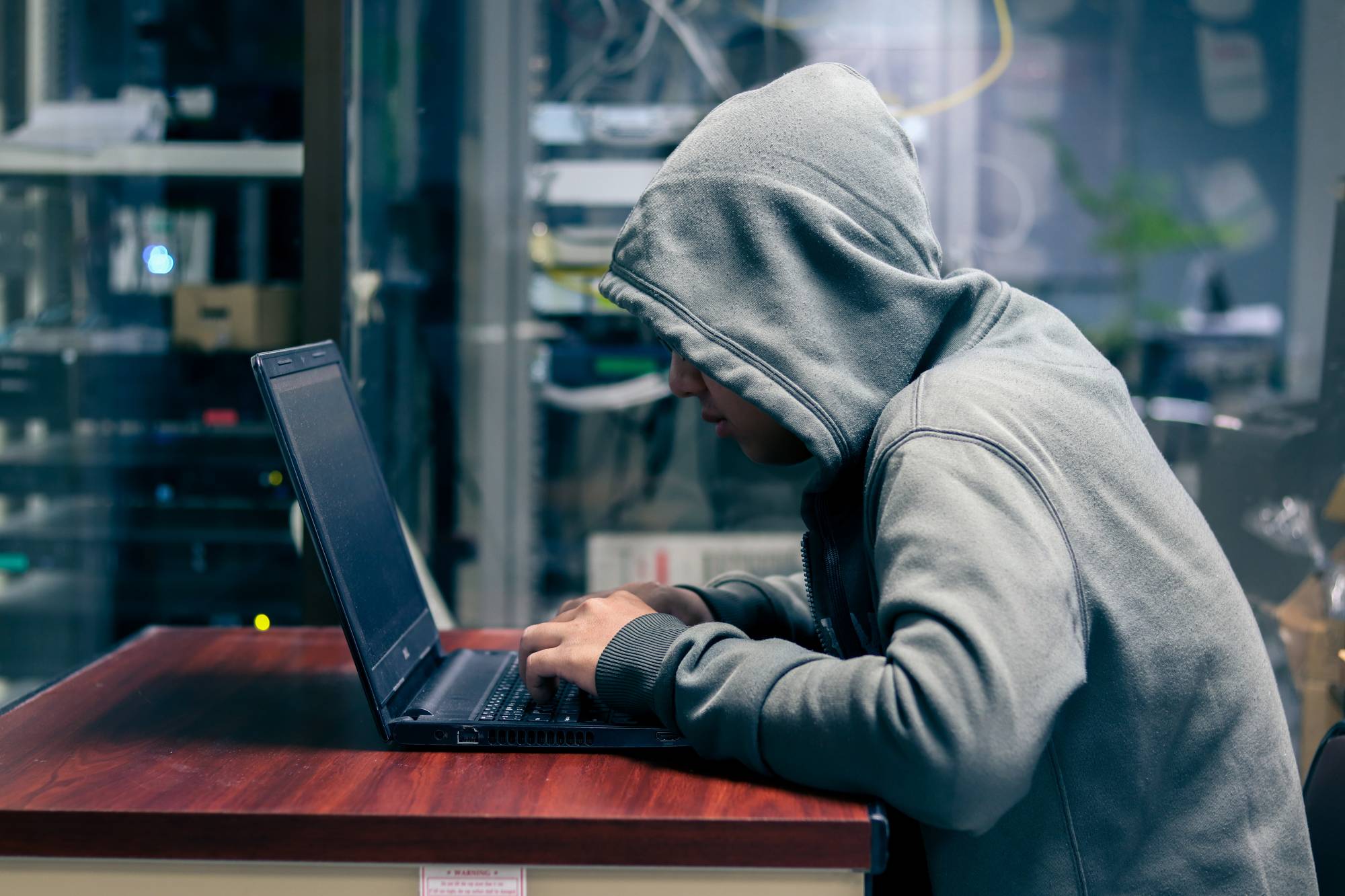 Man in a hoddie on a computer, hacking