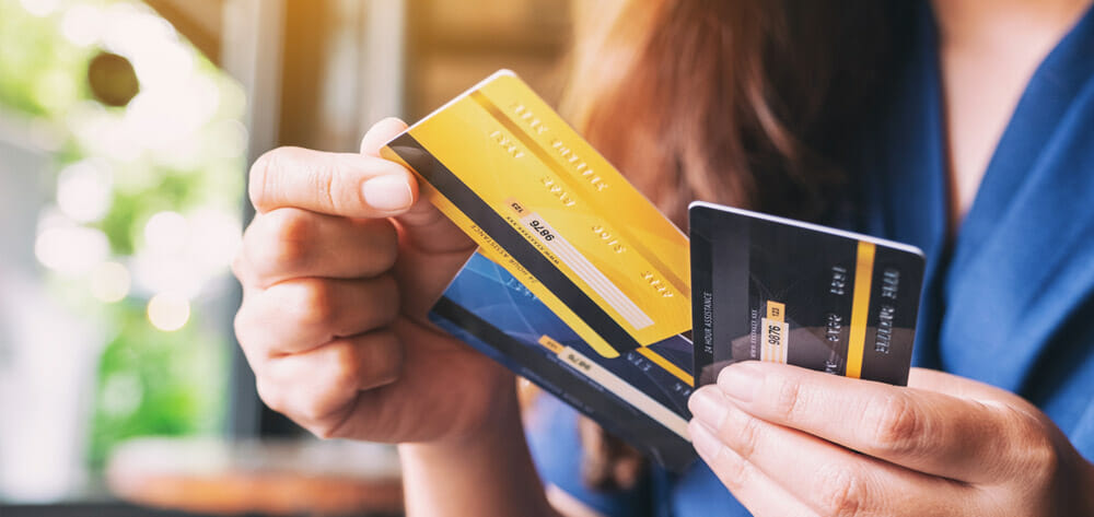 A girl holding three credit cards