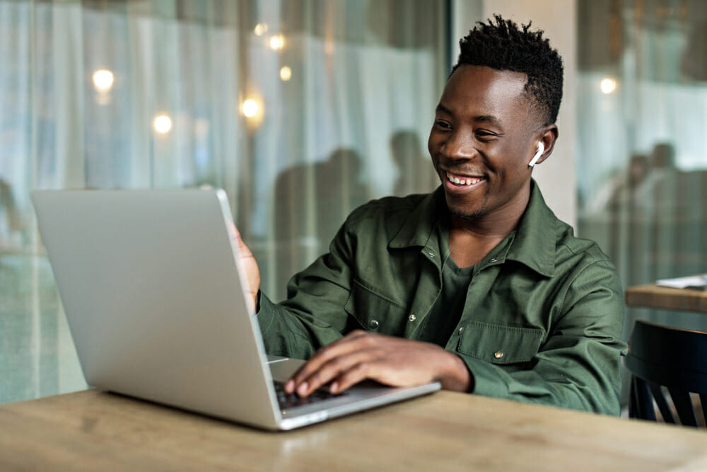 Man smiling at a laptop