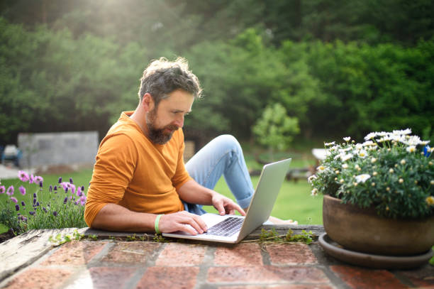 Man lying on the grass with a laptop